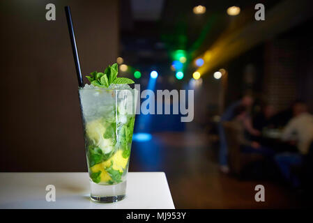 Mojito cocktail glace décoré avec une feuille de menthe et de paille noire sur un comptoir bar close up. Banque D'Images