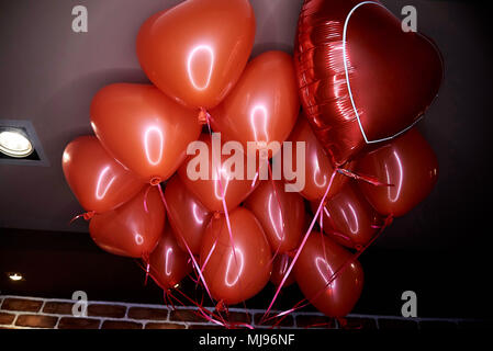 Des ballons rouges en forme de coeur voler sous le plafond Banque D'Images