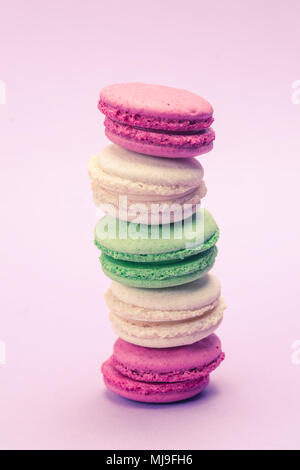 Doux et coloré ou macaron macarons français sur fond mauve, dessert. Banque D'Images