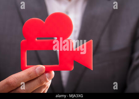 Close-up of a person's Hand Holding Red Movie Camera Banque D'Images