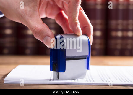 Close-up d'une main du juge d'audience dans le document d'estampage Banque D'Images
