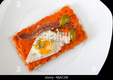 Tapa espagnol composé d'oeuf de caille, d'olive, anchois, poivre et origan Banque D'Images