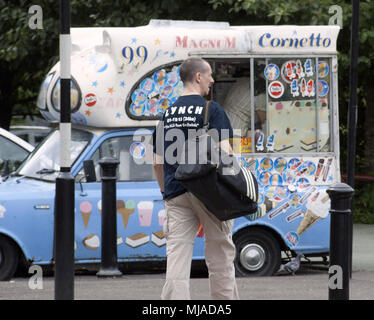 Homme marchant à partir de la salle de sport dans la région de Glasgow avec gorbals hero benny lynch tee shirt sur en face de vintage ice cream van mobile shop Banque D'Images