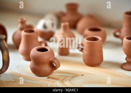 Vaisselle en céramique sur le plan de travail et des étagères dans atelier de poterie, portrait, close-up. Oraganized tasses d'argile ordinaire dans l'atelier. Porce simple Banque D'Images