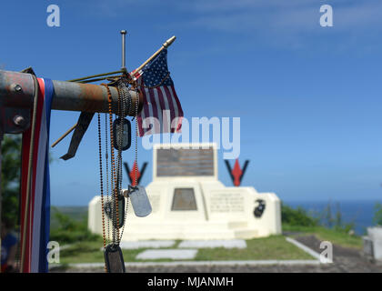 180425-N-CR843-066 À IWO, le Japon (25 avril 2018) un petit drapeau américain sur le sommet des vagues de Mt. Suribachi sur l'île d'Iwo à. Au fil des ans, les visiteurs ont laissé derrière eux une variété de souvenirs de la Seconde Guerre mondiale en hommage aux militaires qui ont combattu vaillamment sur l'île. Mt. Suribachi est le site où quatre marines et un marin a soulevé le drapeau américain pendant les 36 jours de la Deuxième Guerre mondiale, la bataille d'Iwo Jima entre février 19, 1945 - Mars 26, 1945. (U.S. Photo par marine Spécialiste de la communication de masse 2e classe Juan S. Sua/libérés) Banque D'Images