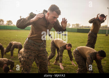 Les Marines américains avec la Force de rotation de la mer Noire 18,1 exécuter burpees avant au sol après un conditionnement de six milles à bord de la randonnée de la Base Aérienne de Mihail Kogalniceanu, la Roumanie, le 27 avril 2018. Randonnées alors que grevé par une charge lourde est une capacité marines ont besoin pour maintenir la forme physique et la préparation au combat. (U.S. Marine Corps photo par le Sgt. Victor A. Mancilla) Banque D'Images