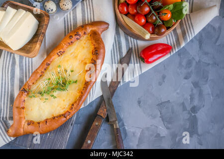 Khachapuri géorgien traditionnel est un pain au fromage. Du pain avec du fromage et des œufs avec les verts. Banque D'Images