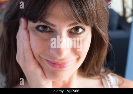 Close up portrait of young woman with long hair et bangs. sourire confiant d'expression. Banque D'Images