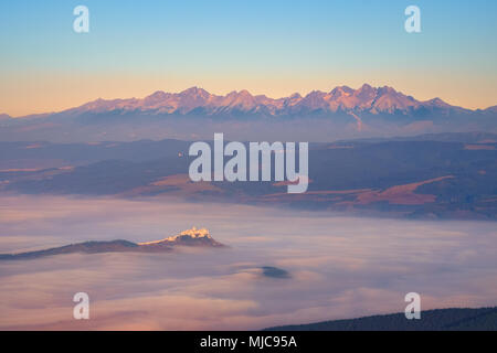 Vue panoramique de montagnes des Hautes Tatras et château de Spis au lever du soleil avec les nuages bas, la Slovaquie Banque D'Images