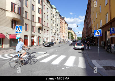 Stockholm, Suède - le 27 juin 2016 : Un cycliste se transforme en Norrbackagatan Rörstrandsgatan de dans le quartier de Vasastaden. Banque D'Images