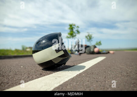 Casque biker se trouve sur rue près d'un accident de moto Banque D'Images