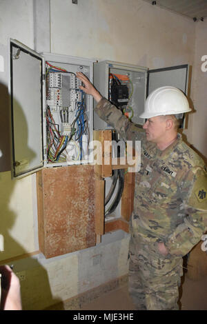 CAMP BUEHRING, Koweït - Premier lieutenant Jonathan Thomas, un agent du 2120th compagnie du génie, 458e bataillon du génie, 35e Brigade d'ingénieur, Groupe de travail Spartan, explique la nature de l'électricité qui doit être corrigée à l'édifice des douanes. (U.S. Army Banque D'Images