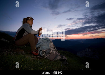 Jeune femme prend une pause pendant la montée de l'Alpspitze, du Wetterstein, à proximité Garmisch, Bavière, Allemagne Banque D'Images