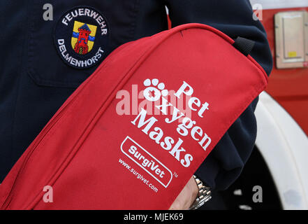 30 avril 2018, Hambourg, Allemagne : Un employé du service d'incendie à Delmenhorst tenant un sac rempli de masques respiratoires pour les animaux domestiques. Le Delmenhorster fire brigade, est l'un des premiers pompiers en Allemagne qui a masques respiratoires pour les animaux domestiques. Photo : Carmen Jaspersen/dpa Banque D'Images