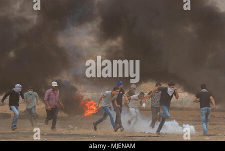 4 mai 2018 - De violents affrontements éclatent à l'est de Gaza du sud de la ville de Khan Yunis, au cours de l'oeGreat de mars Returnâ€ protester pour la sixième fois vendredi. Des manifestants palestiniens ont jeté des pierres vers les forces israéliennes pendant les affrontements près de la clôture frontalière. Gaza-Israeli Un certain nombre de manifestants palestiniens ont été blessés par les balles réelles, des balles en caoutchouc, des gaz lacrymogènes et tiré sur eux les forces de sécurité israéliennes. Palestiniens manifestants ont également brûlé des pneus près de la frontière d'obscurcir la vue des soldats israéliens lourdement armés et bloquer des tireurs embusqués. Des manifestants palestiniens ont recueillir Banque D'Images