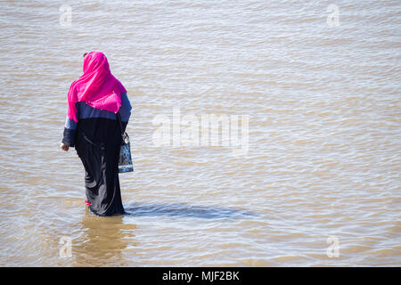 Femme musulmane portant le foulard Hijan pagayer dans la mer. UK Banque D'Images