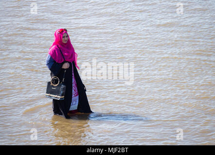 Femme musulmane portant le foulard Hijan pagayer dans la mer. UK Banque D'Images