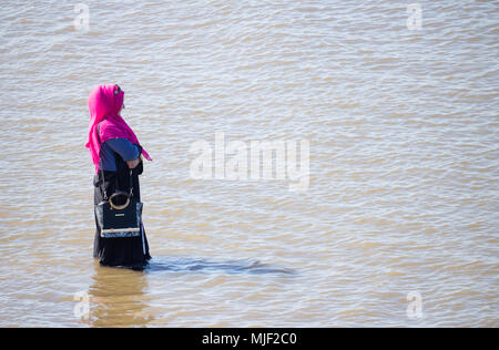 Femme musulmane portant le foulard Hijan pagayer dans la mer. UK Banque D'Images