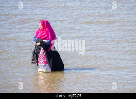 Femme musulmane portant le foulard Hijan pagayer dans la mer. UK Banque D'Images