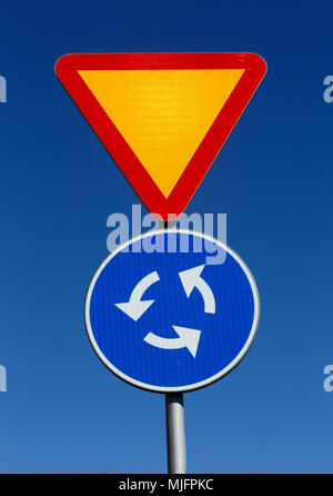 La signalisation routière et rond-point contre le ciel bleu. Banque D'Images