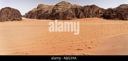 La vacuité du grand désert dans la réserve naturelle de Wadi Rum, avec de grandes montagnes de grès rouge à l'arrière-plan et la vue sur le wid Banque D'Images