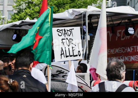 Darmstadt, Allemagne. 04 mai, 2018. Un manifestant est titulaire d'un signe qui se lit "la ville pour tous !". Les réfugiés et les militants ont défilé à Darmstadt, pour protester contre la déportation des réfugiés, qu'ils voient leur pays d'origine comme n'étant pas enregistrer. L'occasion est l'ouverture récente d'un centre d'expulsion de Darmstadt, qui est le premier dans l'état de Hesse. Crédit : Michael Debets/Pacific Press/Alamy Live News Banque D'Images