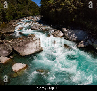 Vue panoramique d'une belle turquoise rivière dévale une chute de rochers sur la Hollyford Road, près de Milford Sound, Parc National de Fiordland, Nouvelle-Zélande Banque D'Images