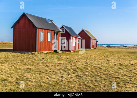 Kapelludden sur Oland, Sweden. Cabines de pêche en bois rouge dans une ligne le long de la côte. Banque D'Images