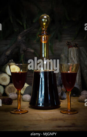 Red Wine Vintage bouteille et verres en appui sur table en bois contre Noël arrière-plan avec le bois de sciage et des branches de Pins Banque D'Images