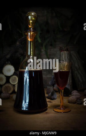 Red Wine Vintage bouteille et verres en appui sur table en bois contre Noël arrière-plan avec le bois de sciage et des branches de Pins Banque D'Images