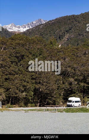 Un camping-car, stationné au camping du ruisseau Cascade sur la route de Milford Sound, Parc National de Fiordland, Nouvelle-Zélande, défini dans un grand hêtre rouge une forêt Banque D'Images