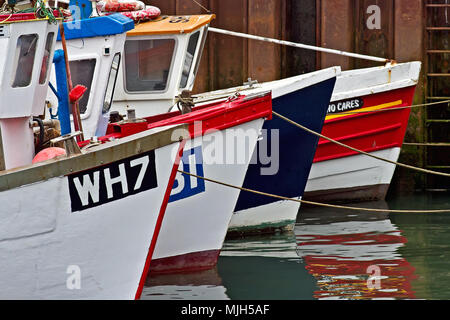 Quatre petits bateaux de pêche forment un alignement géométrique dans le port de Scarborough. Banque D'Images