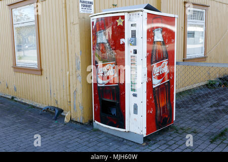 Elverum, Norvège - 3 octobre 2016 : Un distributeur automatique Coca-Cola en plein air à l'extérieur du bâtiment en bois jaune. Banque D'Images