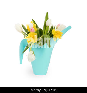 Arrosoir en plastique bleu avec un bouquet de fleurs jaune de jonquilles et tulipes blanches et roses sur fond blanc. Les accessoires de jardin. Banque D'Images