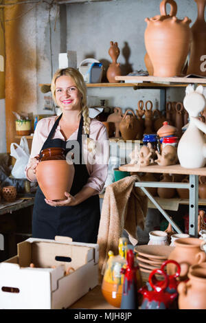 Portrait de femme sourire heureux Travailleur diligent poterie avec vaisselle en céramique dans les mains en studio Banque D'Images