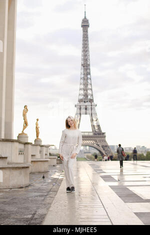 Jolie femme marche sur la place du Trocadéro près de statues dorées et Tour Eiffel. Banque D'Images