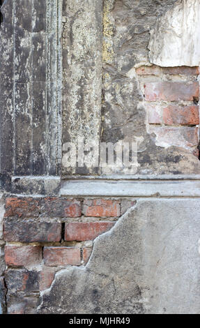 Détail d'une façade ancienne, grise, délabrée avec briques Banque D'Images