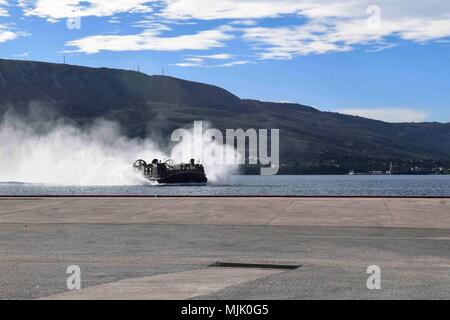 Landing Craft Air Cushion est un aéroglisseur amphibie de l'United States Navy conçu pour le transport rapide entre le navire et la rive. Le 1er décembre 2017, un LCAC attaché à l'unité d'embarcation d'assaut 5 s'approche d'un quai dans la baie de Souda, en Grèce, opérant à partir de l'USS San Diego (LPD 22) lors du déploiement avec l'America Amphibious Ready Group dans la zone de la 6e flotte américaine. L'image d'archives documente l'engin manoeuvrant près du port. Banque D'Images