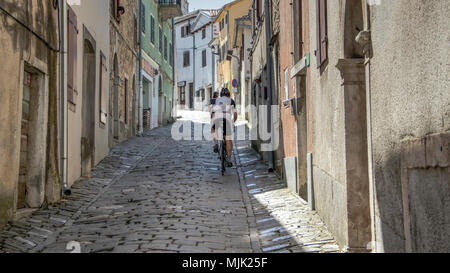 Le centre de l'Istrie, Croatie, avril 2018 - Les cyclistes de remonter la rue pavées étroites dans l'ancienne ville de Motovun Banque D'Images