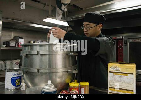 171206-N-UH661-014 Bremerton, dans l'État (déc. 6, 2017) 3ème classe spécialiste culinaire Lieu Brandon, de Lakeland, Floride, prépare le glaçage à gâteau dans la cuisine à bord du USS JOHN C. STENNIS (CVN 74). John C. Stennis est à port effectuant un exercice de routine en tant qu'il continue la préparation de son prochain déploiement. (U.S. Photo par marine Spécialiste de la communication de masse 3 classe Mike Pernick/libérés) Banque D'Images