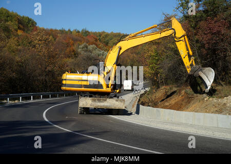 La machine excavatrice travaillant sur la route Banque D'Images