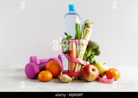 Bouteille de l'eau avec un ruban rose, légumes et fruits. Concept de la santé, de l'alimentation et la nutrition. Banque D'Images