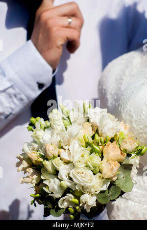 Mariage. La décoration. Chaussures de la mariée, un beau bouquet de mariage, bagues, boutonnière et bijoux sont joliment disposés sur un fond de bois gris. Top v Banque D'Images