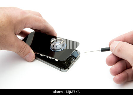 Un POV de droit d'une paire de mains la réparation d'un smartphone endommagé sur un cas isolé sur fond blanc Banque D'Images