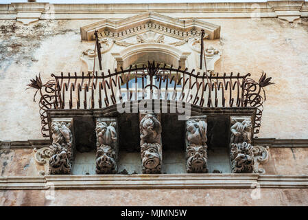 Sculptures de figures fantastiques sur la corniche d'un balcon dans le village historique de Ragusa en Sicile, Italie Banque D'Images