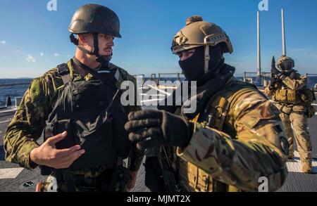 171212-N-KA046-0888 MER MÉDITERRANÉE (déc. 12, 2017) - L'etoile Ethan Allred parle avec un membre des Forces Armées de Malte à bord de la classe Arleigh Burke destroyer lance-missiles USS Carney (DDG 64), au cours d'une visite, un conseil, une perquisition et saisie de l'exercice, le 12 décembre 2017. Carney, l'avant-déployé à Rota, en Espagne, est sur sa quatrième patrouille dans la sixième flotte américaine zone d'opérations à l'appui des alliés et partenaires, et les intérêts de sécurité nationale des États-Unis en Europe. (U.S. Photo par marine Spécialiste de la communication de masse 2e classe James R. Turner/libérés) Banque D'Images