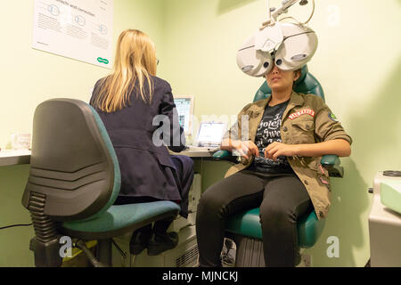 Visite de l'adolescent dans la rue Specsavers Sankey, Warrington, Cheshire, Angleterre, Royaume-Uni le 05 mai 2018 a ses yeux testés à l'aide de la technologie moderne Banque D'Images