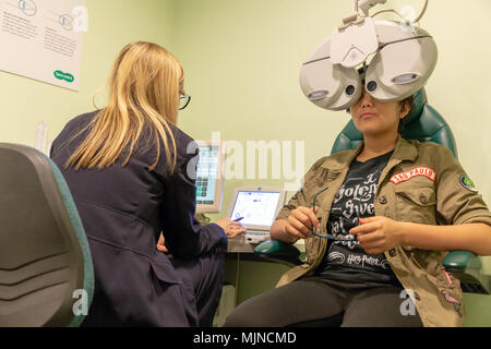 Visite de l'adolescent dans la rue Specsavers Sankey, Warrington, Cheshire, Angleterre, Royaume-Uni le 05 mai 2018 a ses yeux testés à l'aide de la technologie moderne Banque D'Images