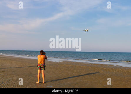 Man taking photo d'avion à l'atterrissage à McKenzie plage près de l'aéroport international de Larnaca Banque D'Images