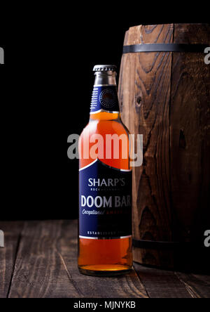 Londres, Royaume-Uni - Mai 03, 2018 froid : bouteille de Sharp's Bar Doom sur amber ale avec tonneau en bois sur fond sombre. Banque D'Images